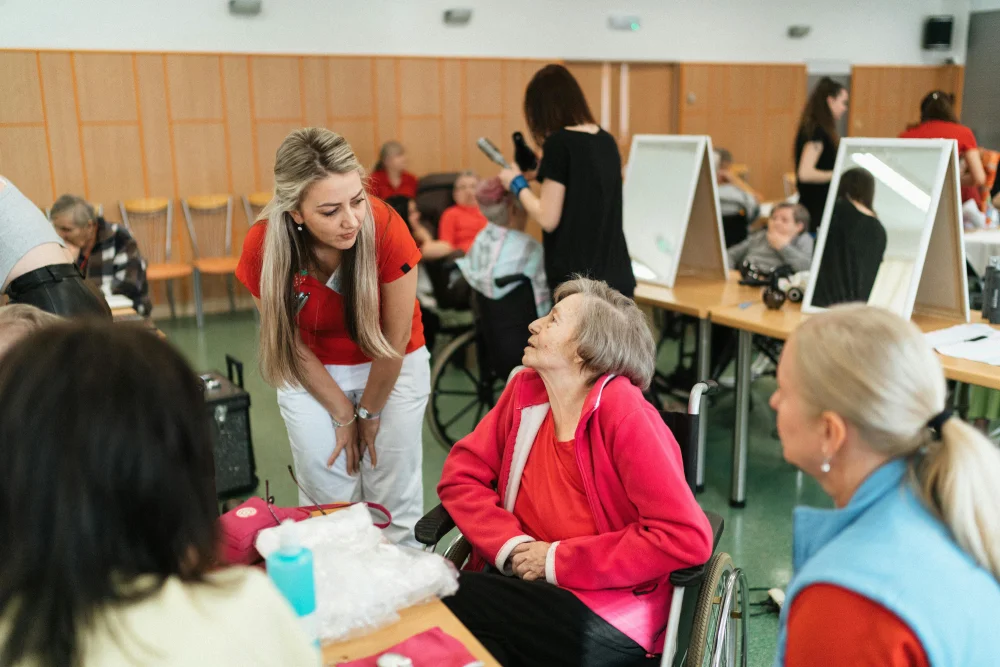Community event in a care facility where volunteers assist and engage with elderly residents, offering grooming services and friendly conversations.